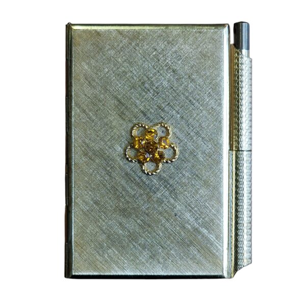 Bloco de notas vintage com caneta e detalhe floral